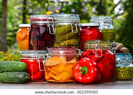 Jars of pickled vegetables and fruits in the garden. Marinated food.