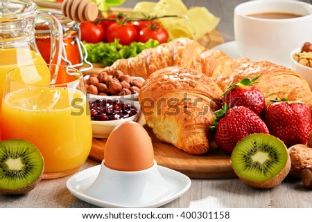 Breakfast consisting of croissants, coffee, fruits, orange juice, coffee and jam. Balanced diet.