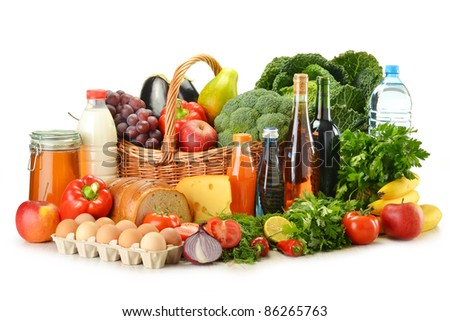 Groceries in wicker basket including vegetables, fruits, bakery and dairy products and wine isolated on white