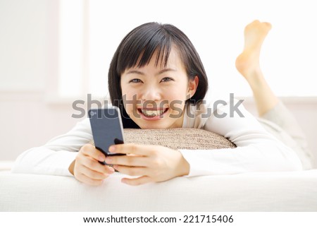 young woman using smart phone on the bed