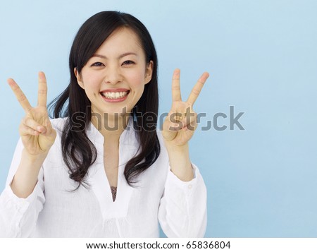 stock photo Happy young japanese girl showing victory sign isolated on