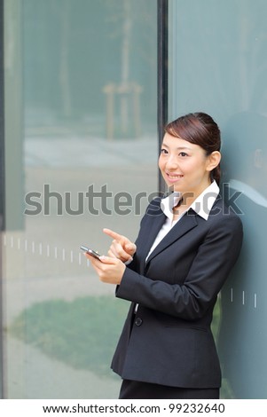 A beautiful young asian business woman on the cell phone at office