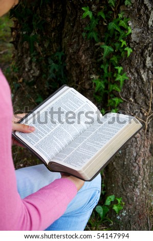 Young reading the Bible in nature