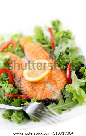 fried salmon with salad isolated on white