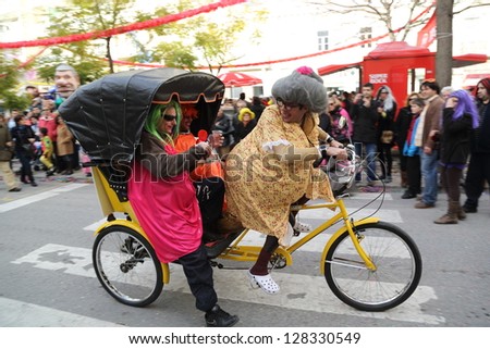 LOULE, PORTUGAL - FEB 12:  People in masks riding a bike on February 12, 2013 in Loule, Portugal.
