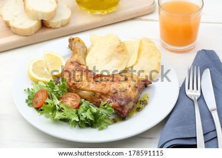 dish of roasted chicken leg on a wood table