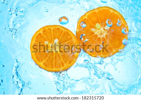 pouring water in two organic tangerines half
