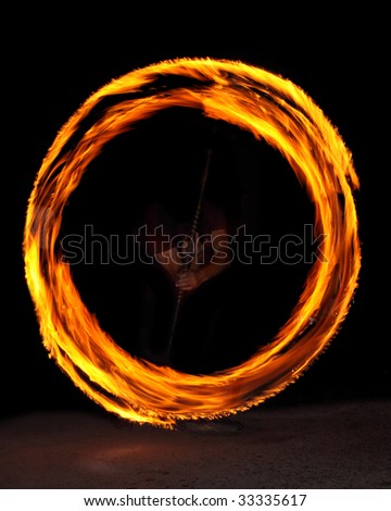 fire performer in the center of a fire circle