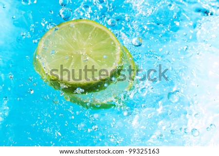 Lime splash in water, top view, bubbles with fruit reflection