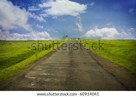 Straight and beautiful old Road over mountain top with grass field on both sides.
