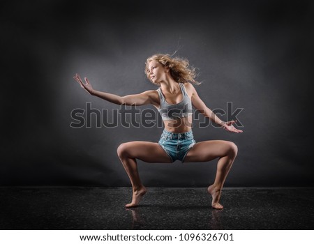One person,  dancer, woman in dynamic beautiful action figure under lights in background.