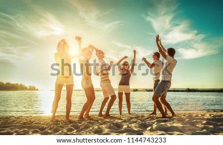 Happiness Friends funny dance on the beach under sunset sunlight in summer sunny day.