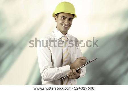 Young architect wearing a protective helmet standing on the building outdoor background