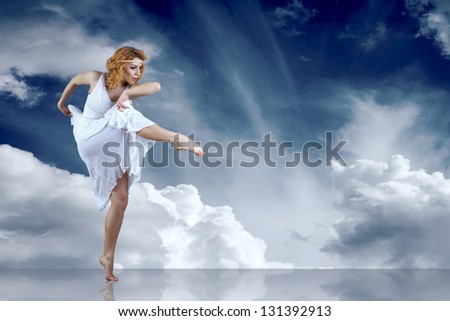 Dance element of ballerina in white under sky