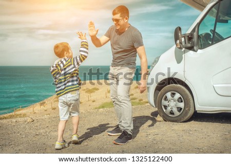 Happiness father and son, stay near them white travel car and look on the beautifull ocean coastline view in sunny day. Freedom, Family, Travell, Journej, Togetherness concept.