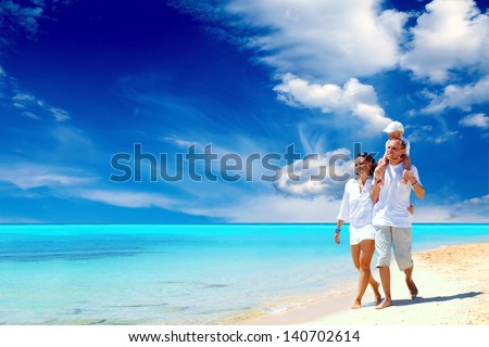 View Of Happy Young Family Having Fun On The Beach