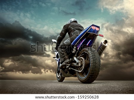 Man seat on the motorcycle under sky with clouds