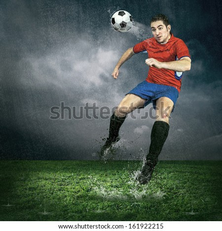 Football player with ball in action under outdoors rain