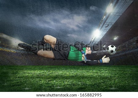 Football golkeeper with ball in action under rain in stadium