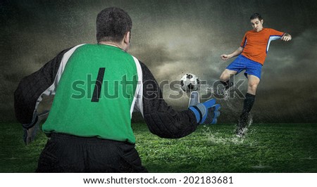 Two Football players in action under rain outdoors