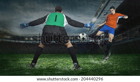 Two football players in action under rain in stadium