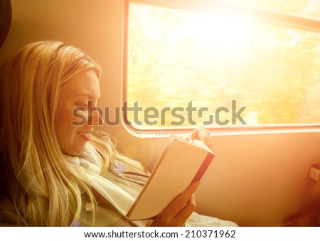 Happiness woman reading book in train under sunlight