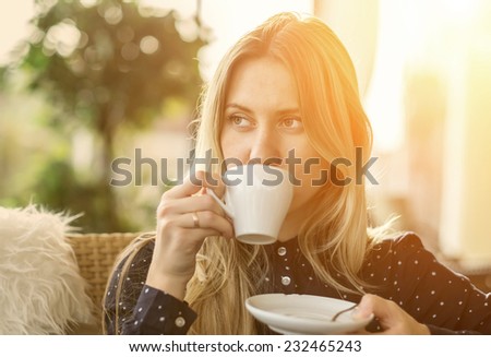 Beautiful blonde female drink coffee in cafe