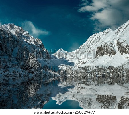 Beautiful mountains view with reflex at winter under sky.