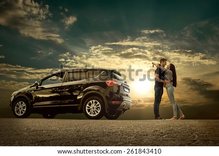 Happiness couple stay near the new car under sky