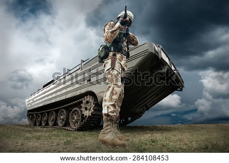 Military tank and soldier outdoors.