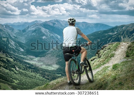Men with bicycle aroun mountains beautiful view.