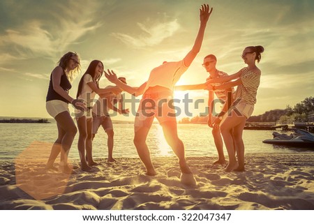 Friends funny game on the beach under sunset sunlight.