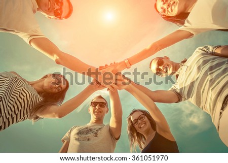 Group of friends on the beach under sunlight.