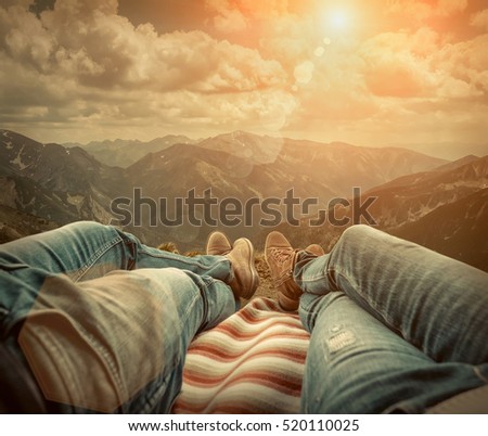 Couple in car. Blonde female and male in jeans in them car looking on beautiful mountains view at autumn day.