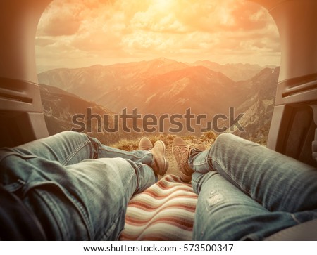 Couple in car. Blonde female and male in jeans in them car looking on beautiful mountains view at autumn day.