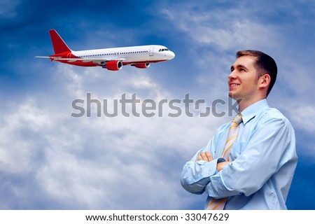 man looks at airplane in air with blue sky