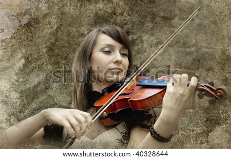 Beautiful female violinist playing violin on the grunge background