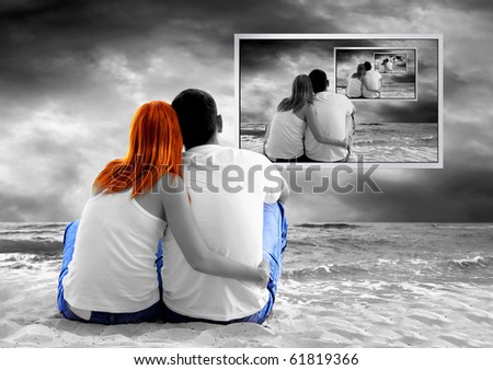 Sea view of a couple sitting on beach and see TV monitor