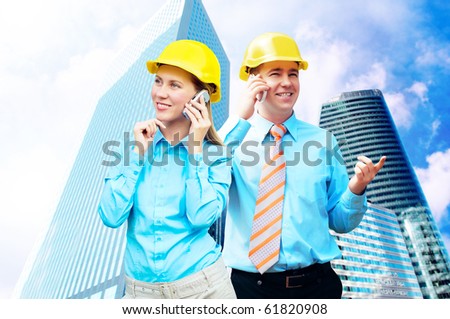 Young architects wearing a protective helmet standing on the building background