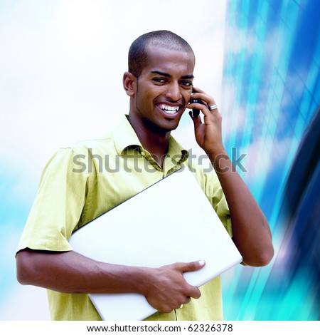 Young happy black man or student with laptop on the business background