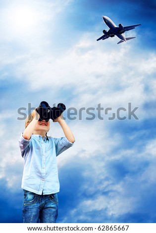 Young boy watch in the field-glass under sky