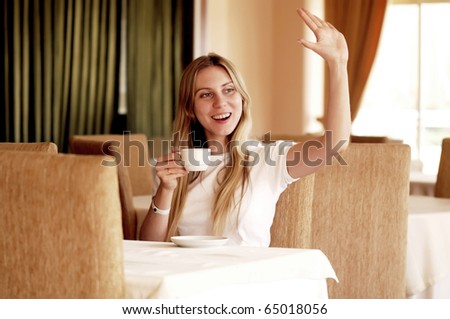 Happy woman in white with cup of coffee or tea.
