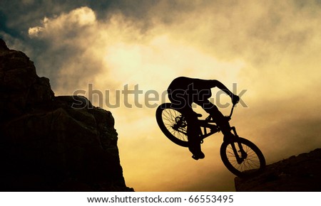 Silhouette of a man on muontain-bike, sunset