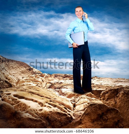 Happy Businesswoman standing with laptop on the mountain under blue sky