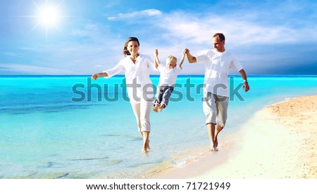View of happy young family having fun on the beach