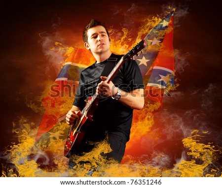 Rock guitarist play on the electric guitar around fire flames
