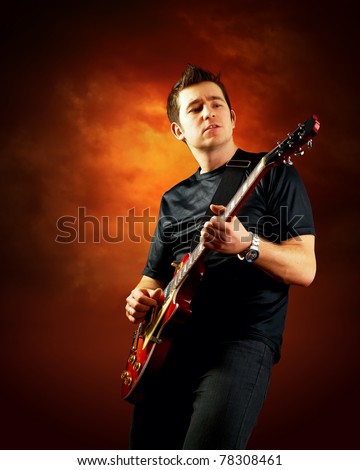Rock guitarist play on the electric guitar, orange sky background