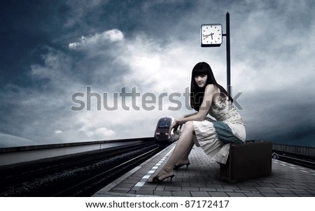 Girl waiting train on the platform of railway station