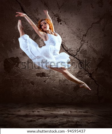 Woman dancer jump posing on background