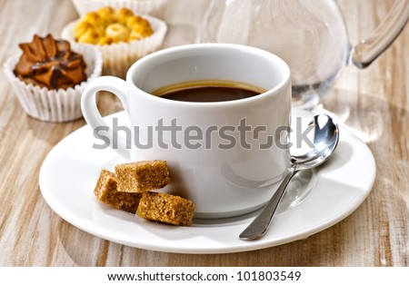 coffee, sugar, water and cakes on wooden board textured
